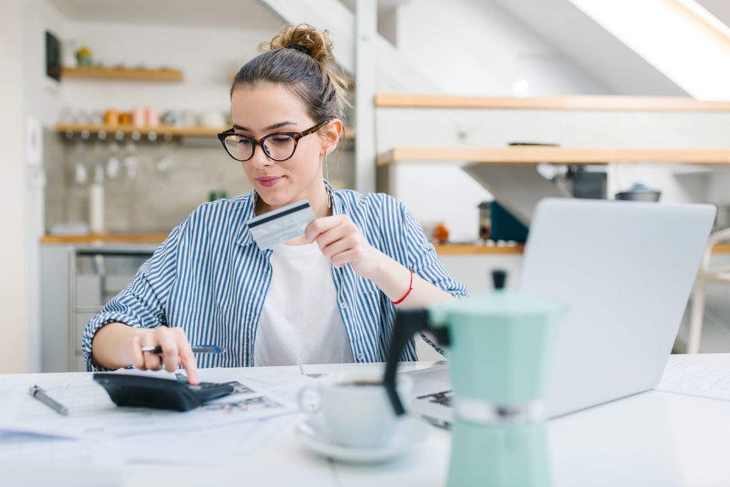 Woman with a credit card, illustrating credit score tips