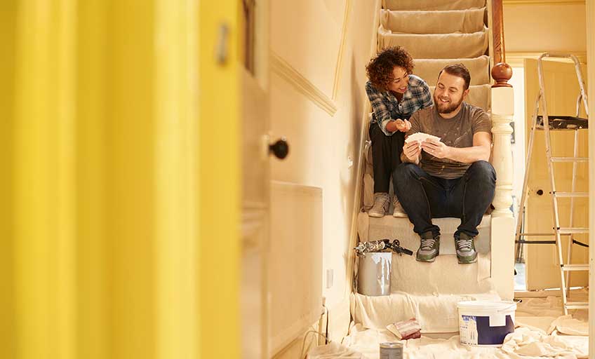 A couple painting the house