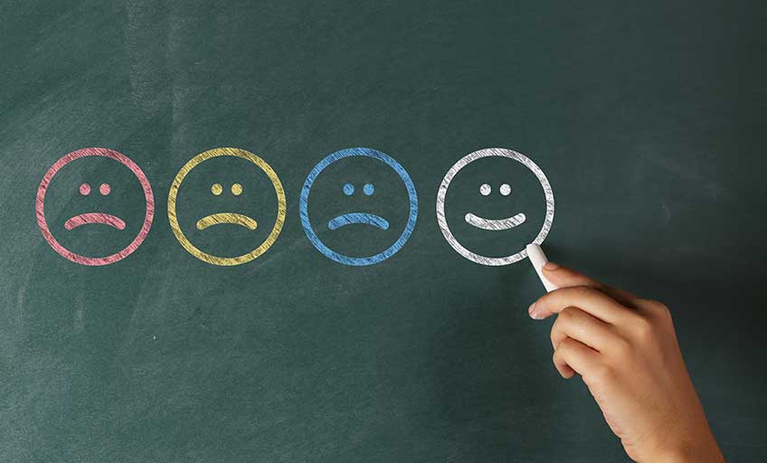 A person drawing a smiley face on a board