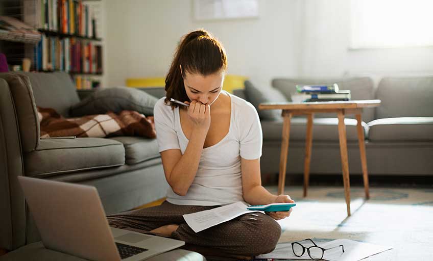 An image of a woman calculating her expenses.