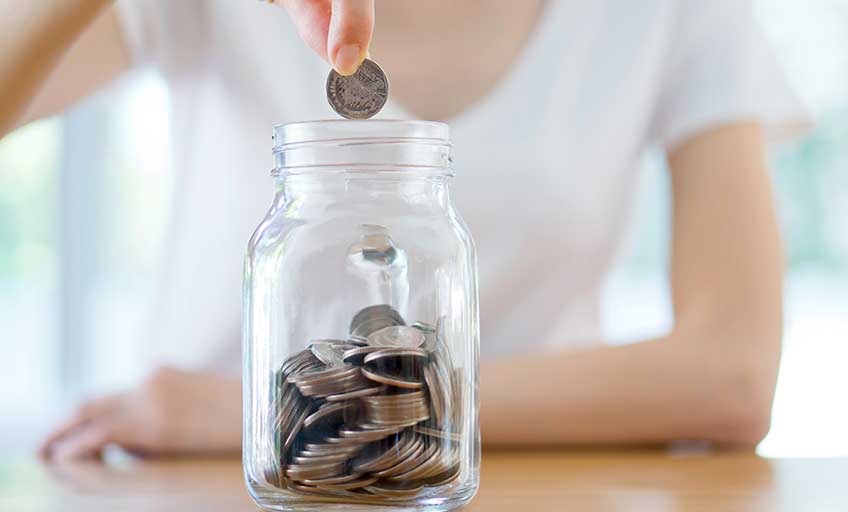 Consistent savings represented by coins in a bottle