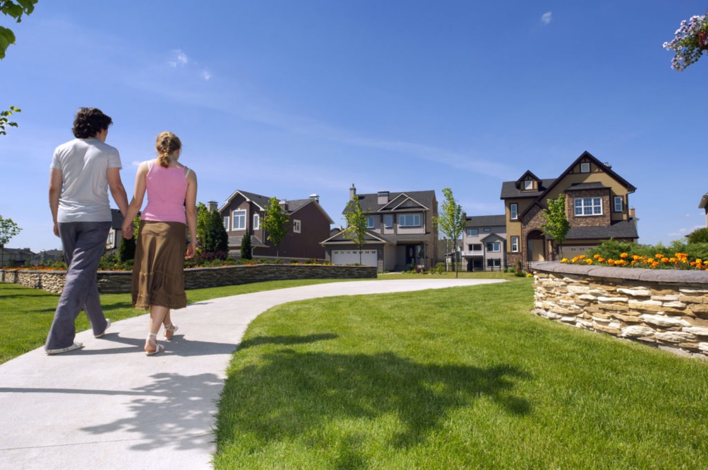 Two people walking near a house