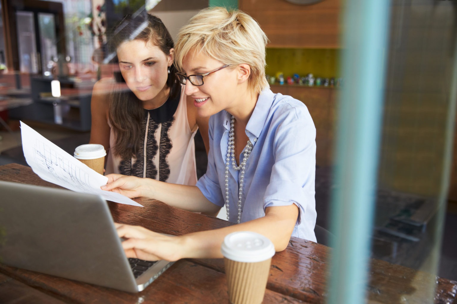 Two women looking at a laptop and discussing.