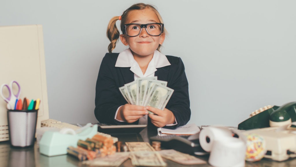 A small girl holding currency