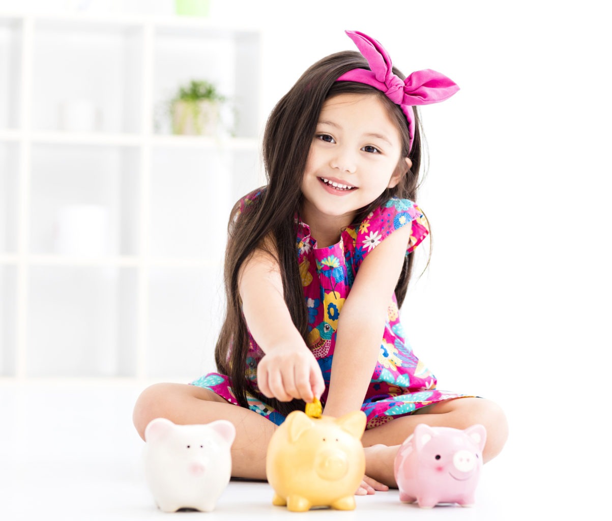 An image of a child with a piggy bank