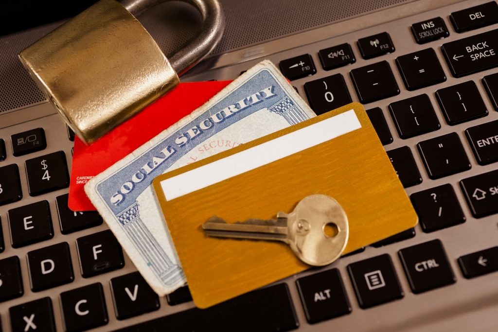 Close-up of a laptop with a lock, key, and cards