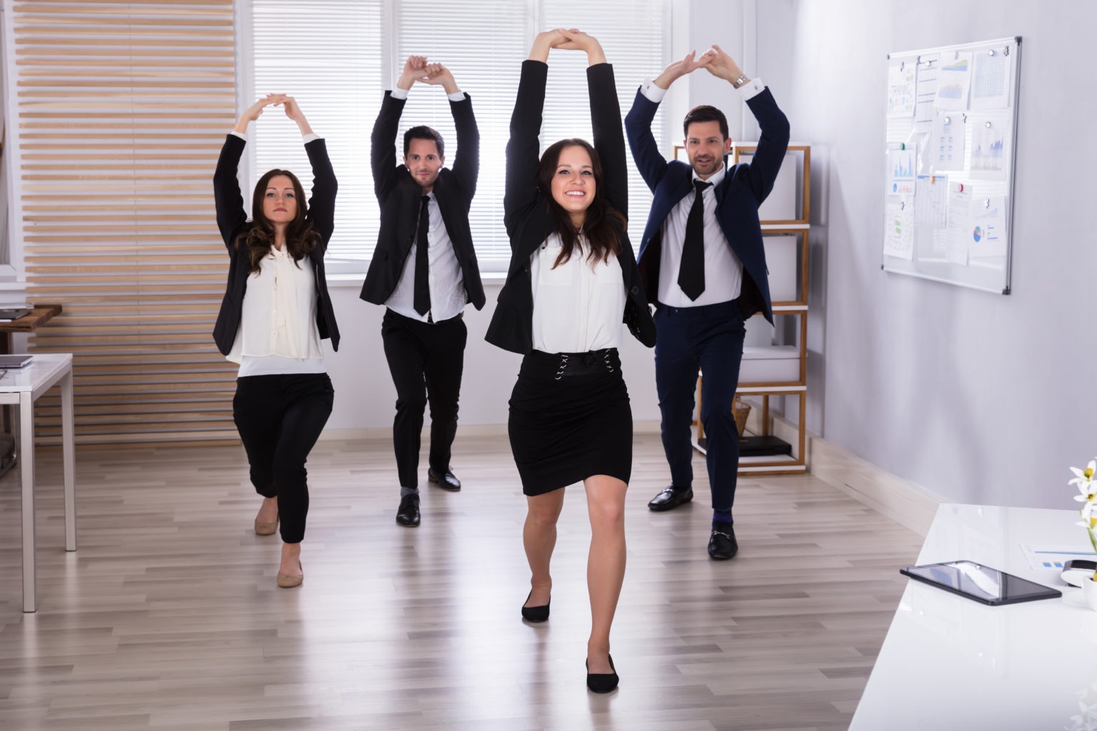 Businesspeople Doing Stretching Exercise Young Businesspeople Doing Stretching Exercise At Workplace