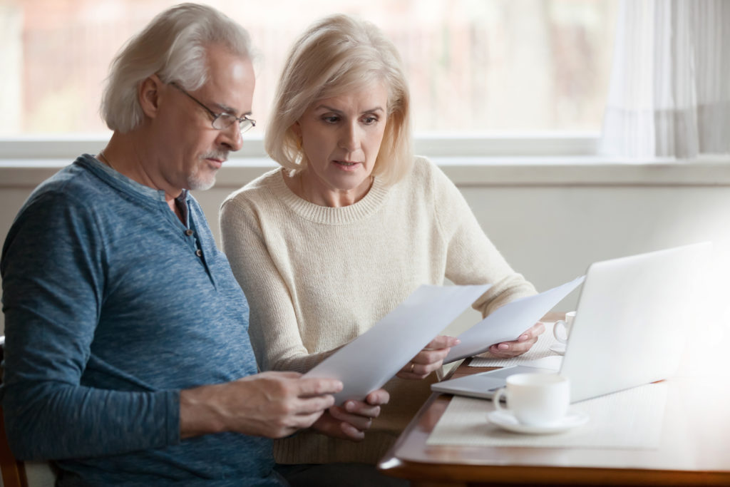 Serious worried senior couple calculating bills to pay or checking domestic finances stressed of debt, retired elderly old family reading documents concerned about loan bankruptcy money problems