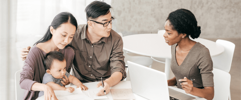 Family - mom, dad and baby - meeting with a mortgage loan officer. 