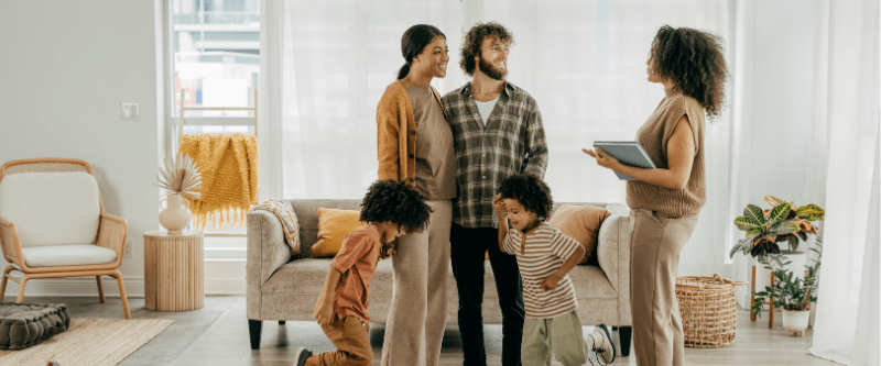 Parents and children looking at a new home with a real estate agent.